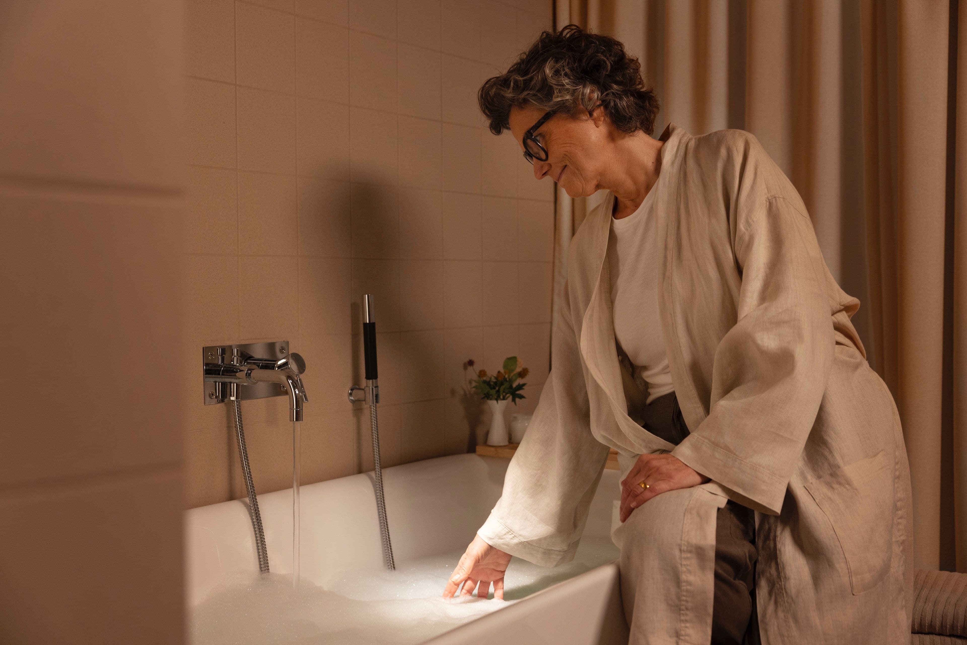 Eine Frau lässt sich Wasser in die Badewanne