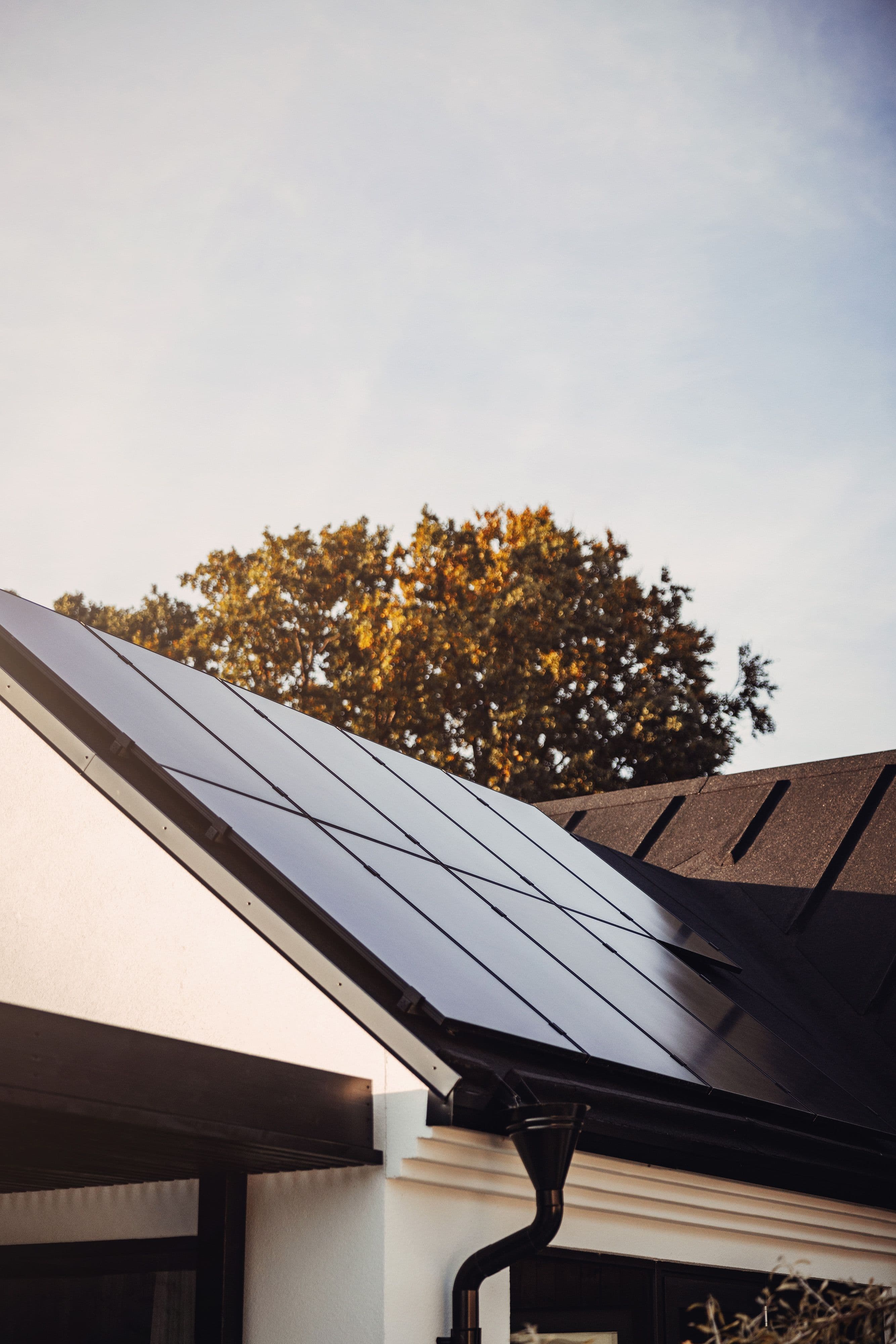 Haus mit Photovoltaik auf einem Spitzdach bei Sonnenuntergangsstimmung