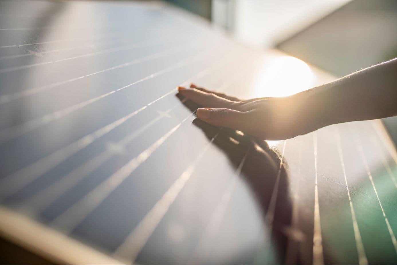 A solar panel reflecting light with a hand touching it