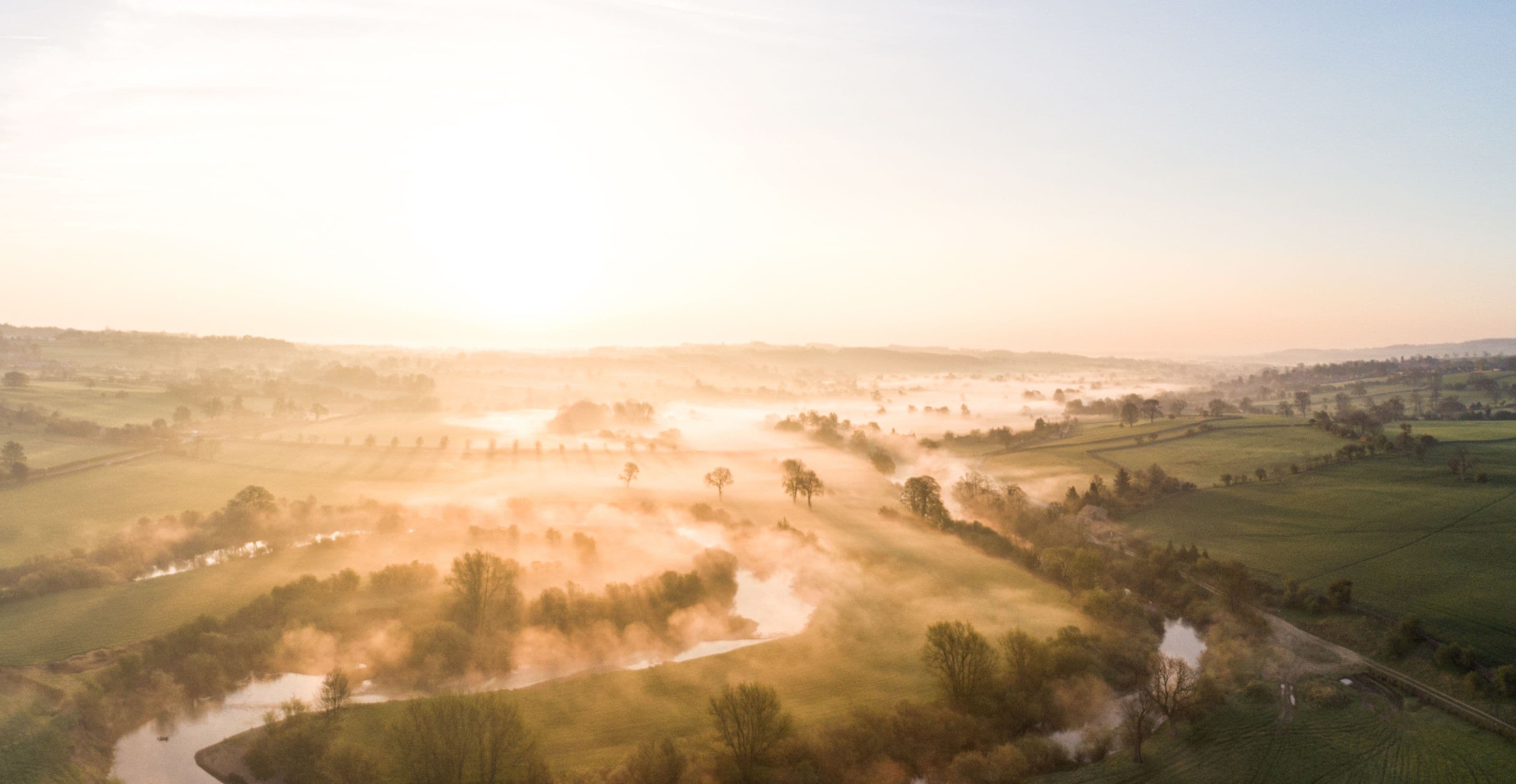 River snaking through a green, misty landscape