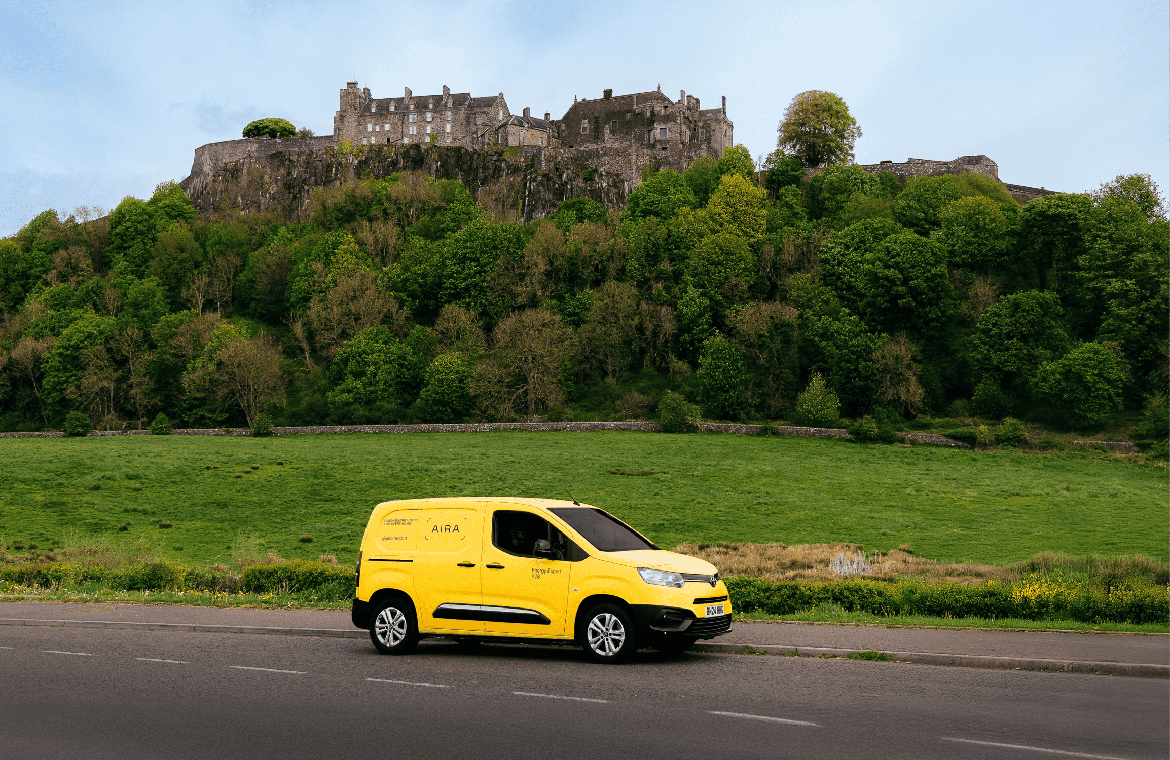 Aira Van driving through Scotland with a caslte in the background