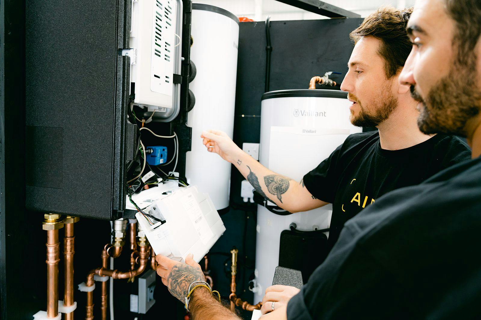Two Aira clean energy technicians working on a heat pump installation