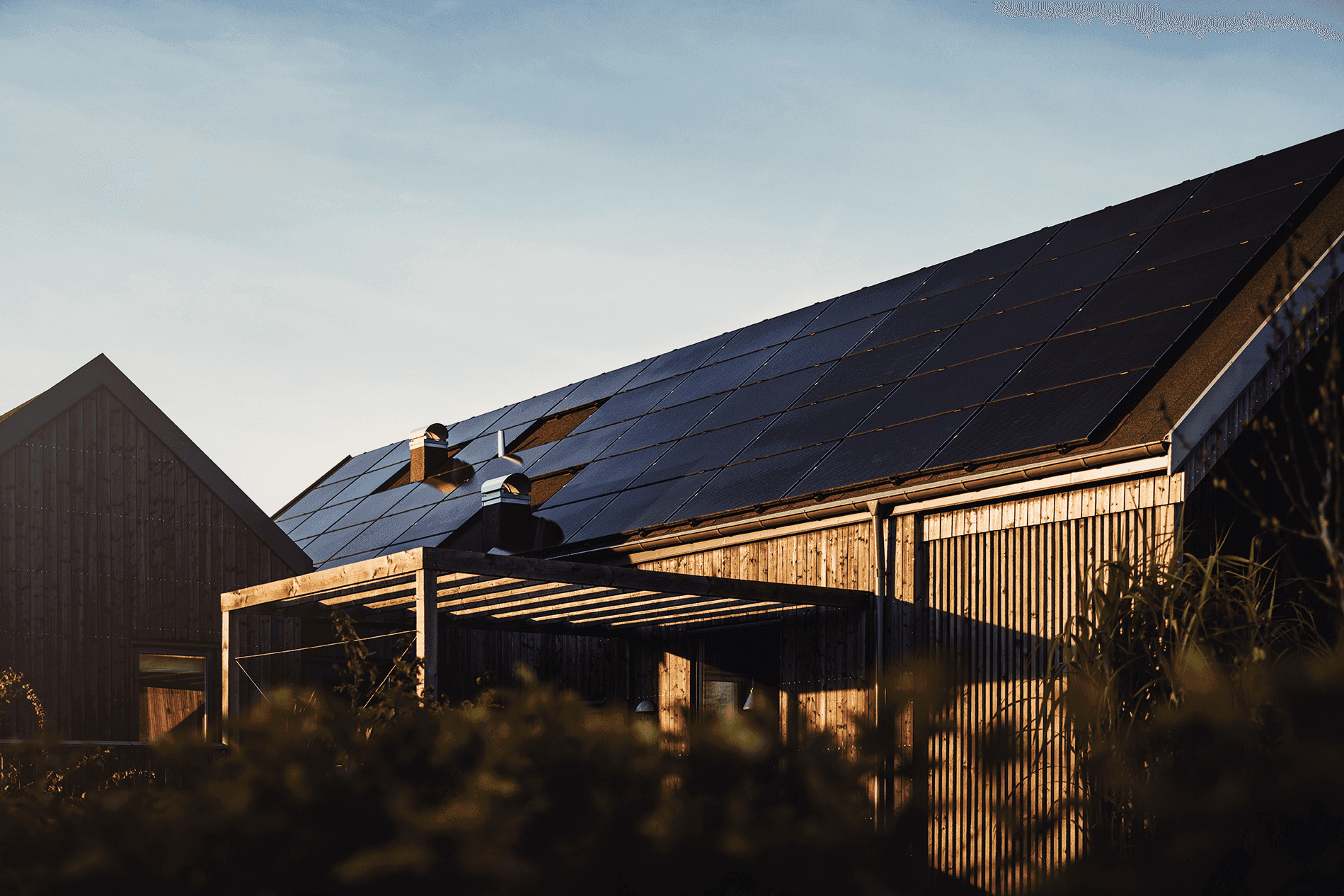 Haus mit Photovoltaik auf dem Dach bei Sonnenuntergangsstimmung
