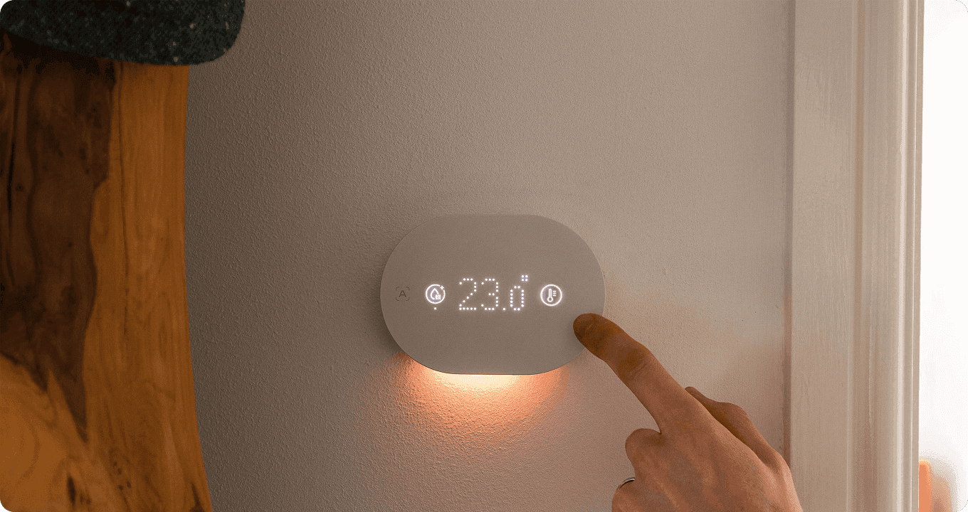 A person setting the temperature to 23 degrees