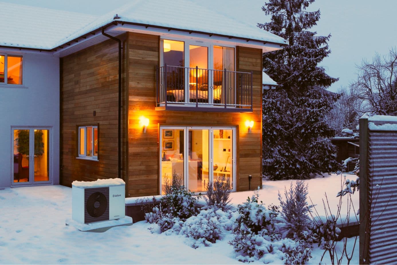 An air source heat pump outside a home in the snow