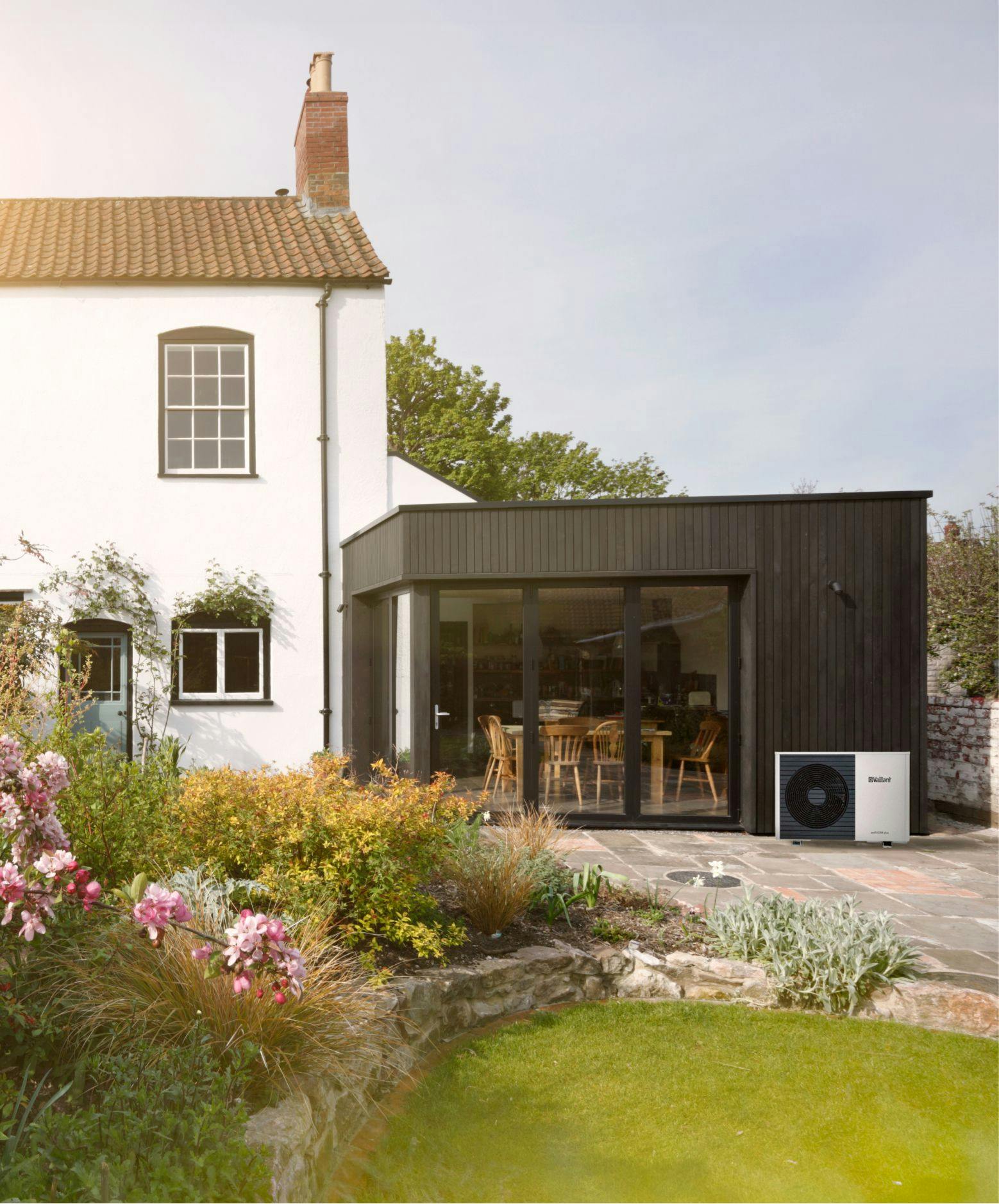 House with a side extension and an air source heat pump